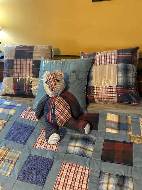 A matching memory quilt, pillows, and bear made from plaid shirts