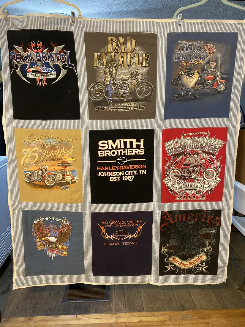 A T-shirt quilt made from bike rally shirts, with striped framing