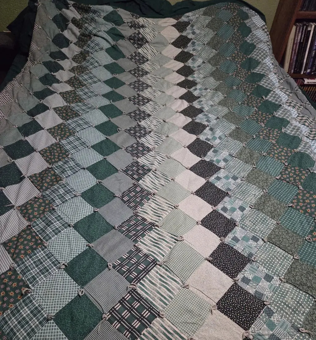 A tied green patchwork quilt, repaired