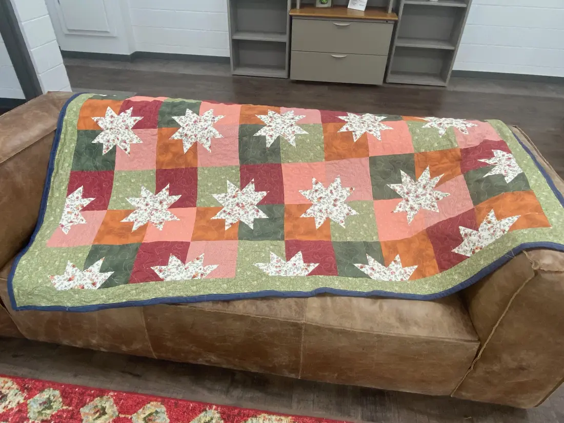 A star quilt in rose, rust, and green